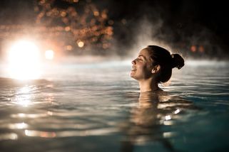 a woman bathes in a thermal bath in hungary at night