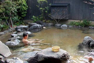 Man ontspant in een Onsen (Japanse thermaalbad)